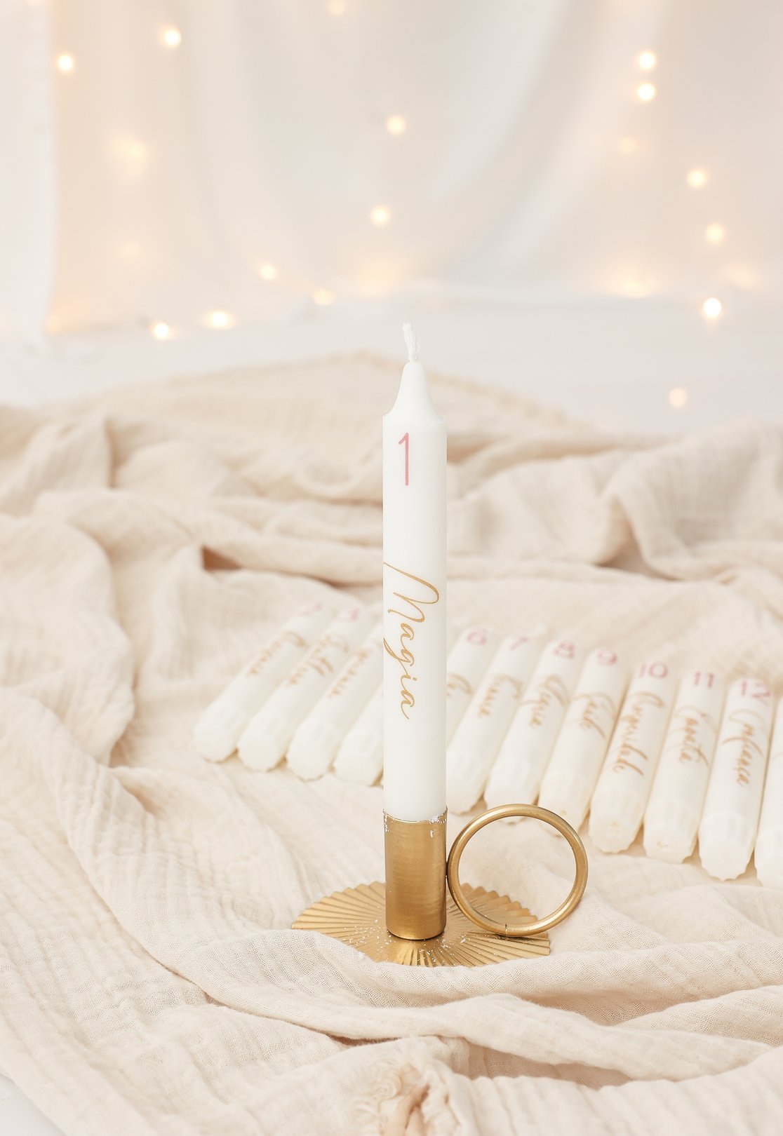 Calendário do Advento de velas com uma vela acesa e as restantes velas numeradas